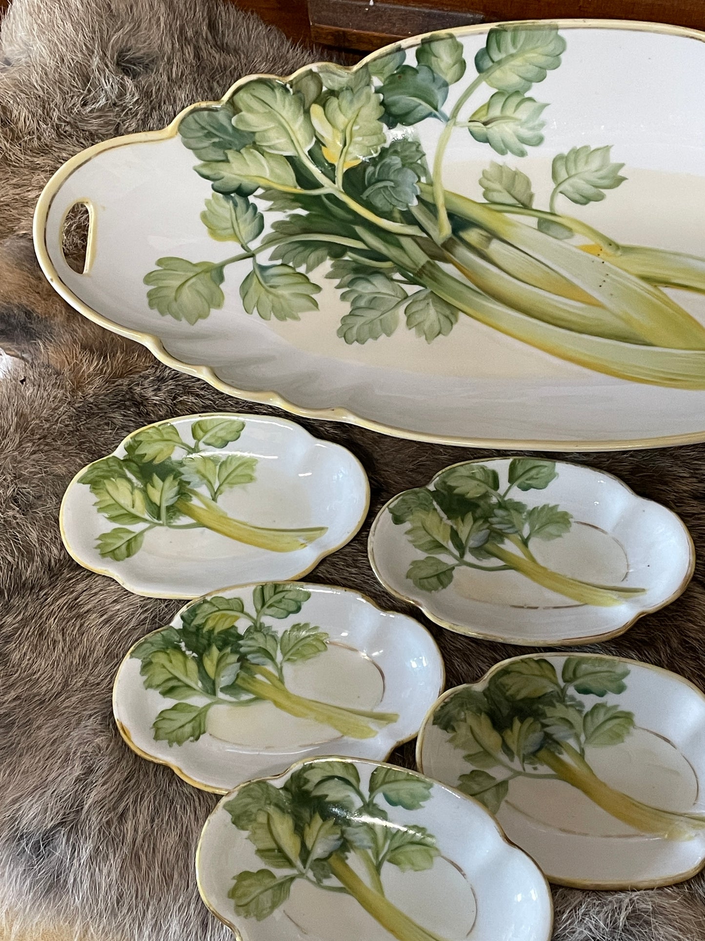 Vintage Nippon celery dish with matching salt cellars photographed on a lace-covered table with natural light and farmhouse decor. Multiple angles show hand-painted celery design, gold trim, and cutout handles.