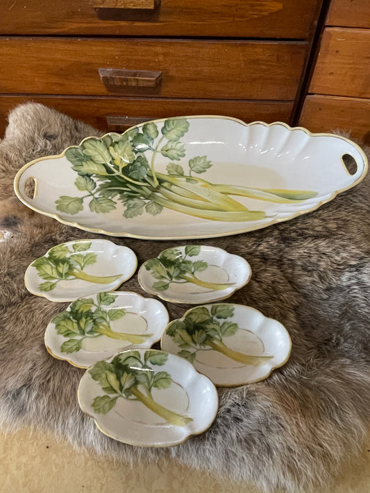 Vintage Nippon celery dish with matching salt cellars photographed on a lace-covered table with natural light and farmhouse decor. Multiple angles show hand-painted celery design, gold trim, and cutout handles.