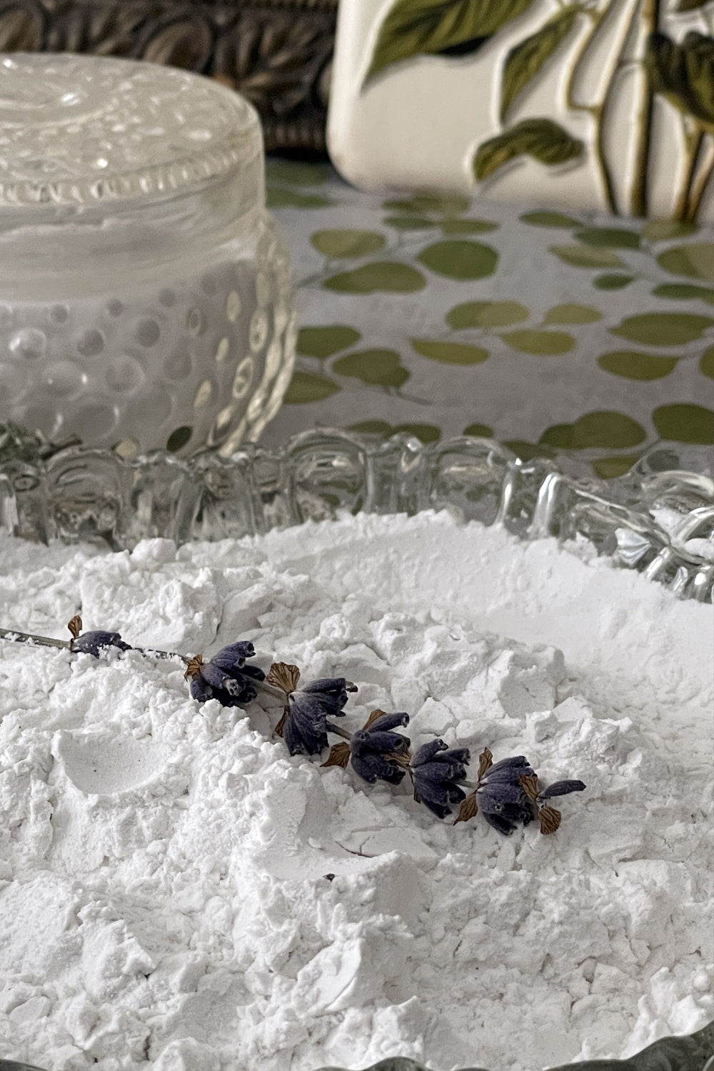 Bulk loose botanical dusting powder in kraft pouch packaging, offered as refill for Stillroom glass shaker bottles.