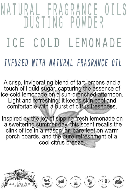 A beautifully styled product card featuring the "Ice Cold Lemonade Organic Body Dusting Powder" leans against a rustic wooden backdrop. The soft, citrus-inspired hues and elegant lettering reflect the fresh, cooling essence of summer lemons.