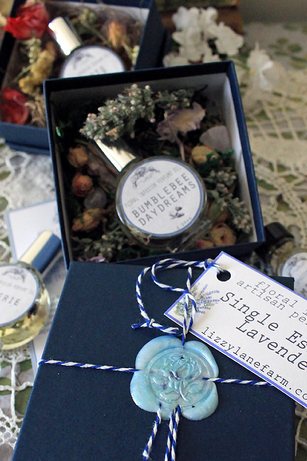 Unboxing Stillroom Perfume — dried botanicals, wax seal, and story cards arranged by hand.