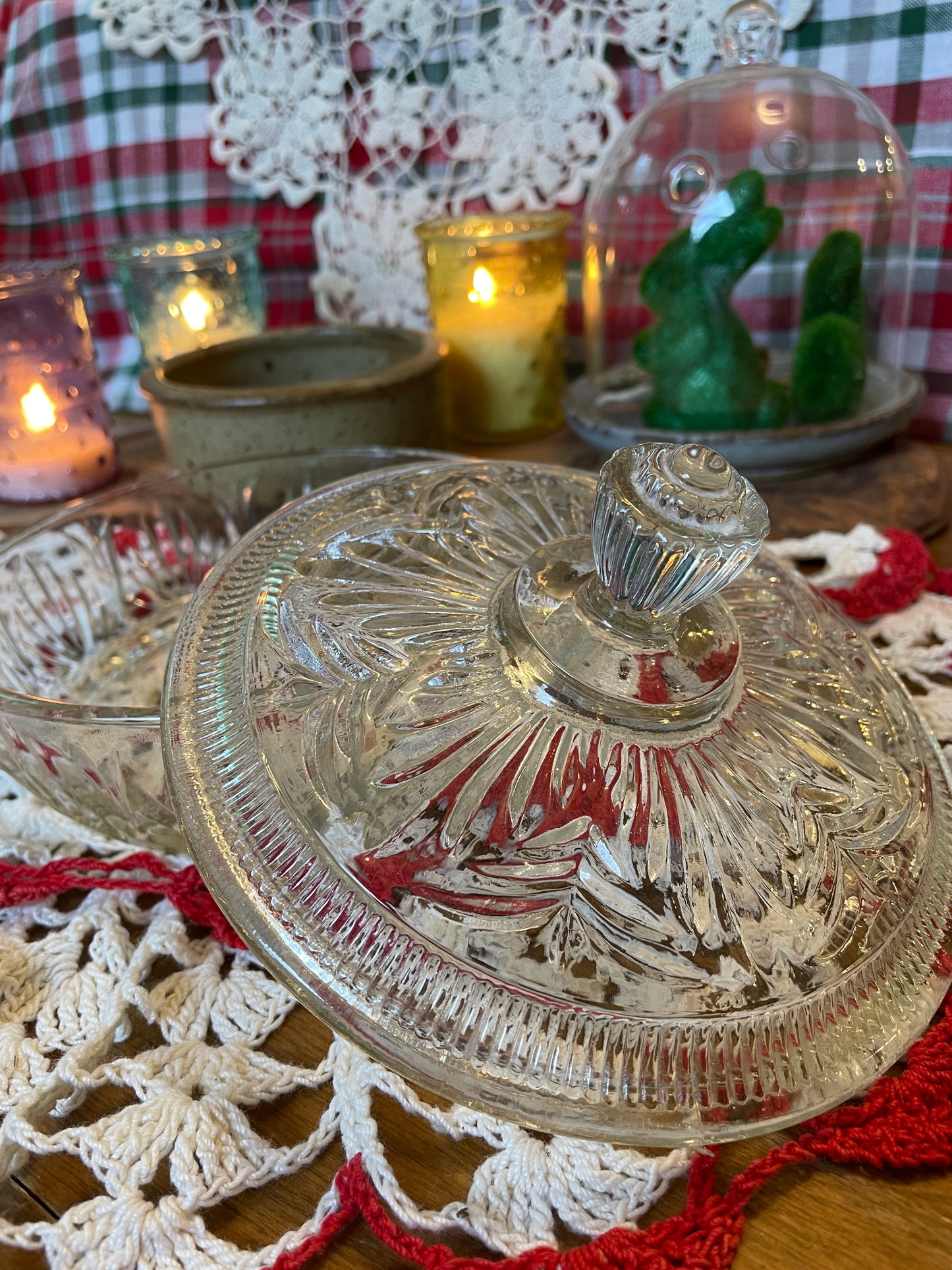 Close-up of the top of the Avon powder dish, highlighting the beautiful finial and pressed glass texture.