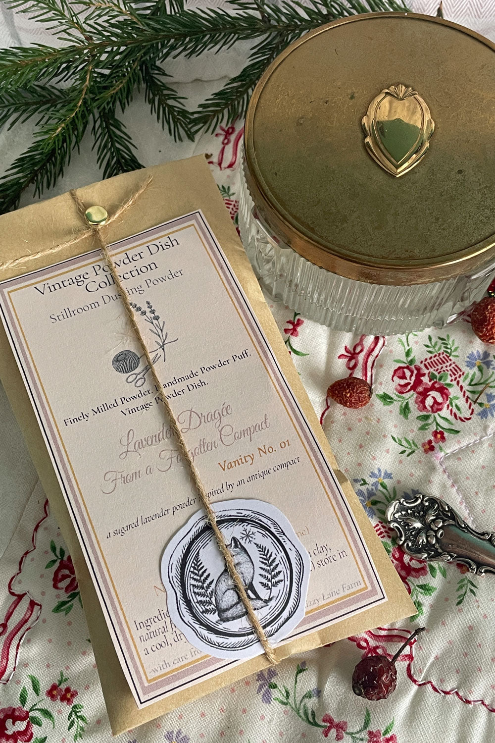 Close-up of vintage powder dish with brass Art Deco lid and Stillroom Archive Cards — styled as a holiday gift set for Stillroom dusting powders such as Lavender Dragée.