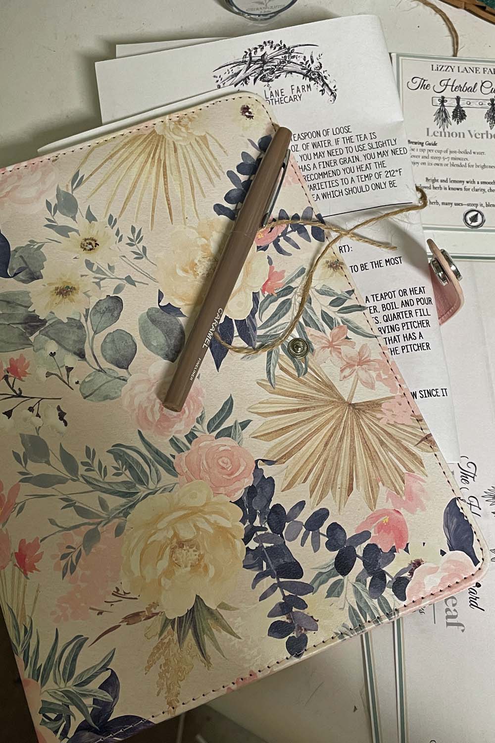 The free tea brewing guide peeking out from a floral journal ready to make tea