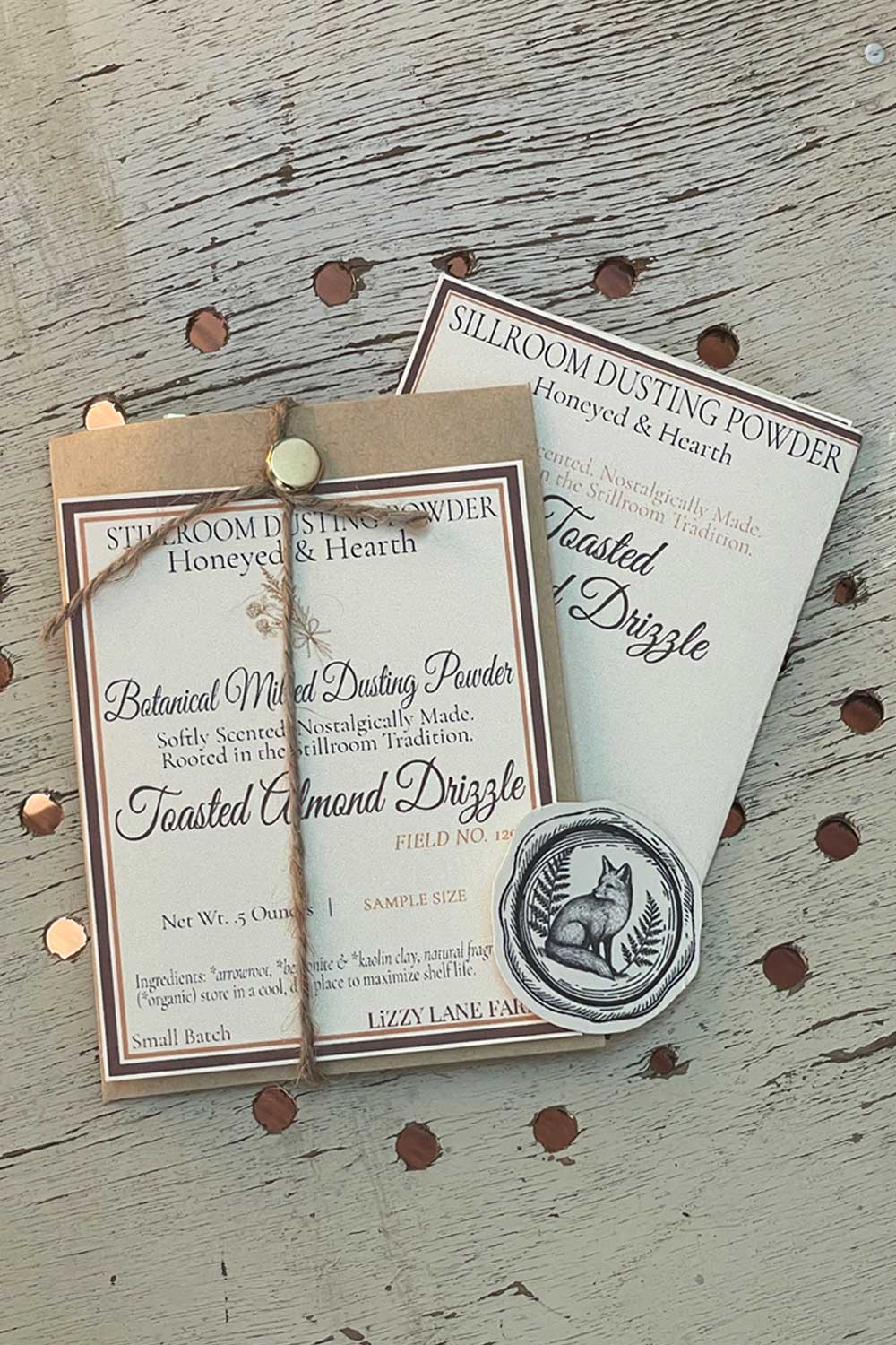 Toasted Almond Drizzle Dusting Powder, 12 oz bulk edition with Stillroom Archive fragment cards — vintage farmhouse holiday scent with goldenrod icon.