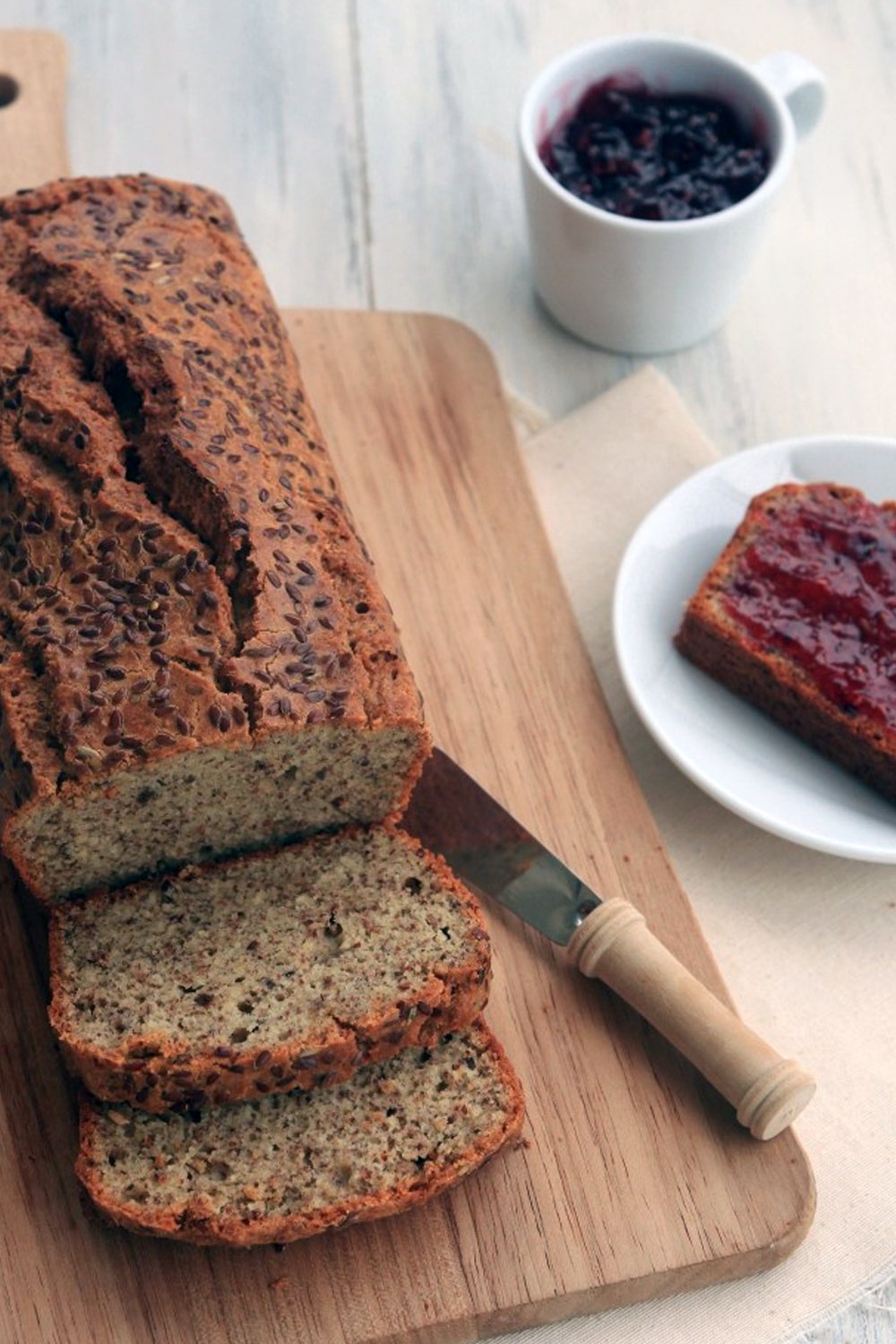 freshly baked loaf of flaxseed breas sliced and ready to be enjoying.
