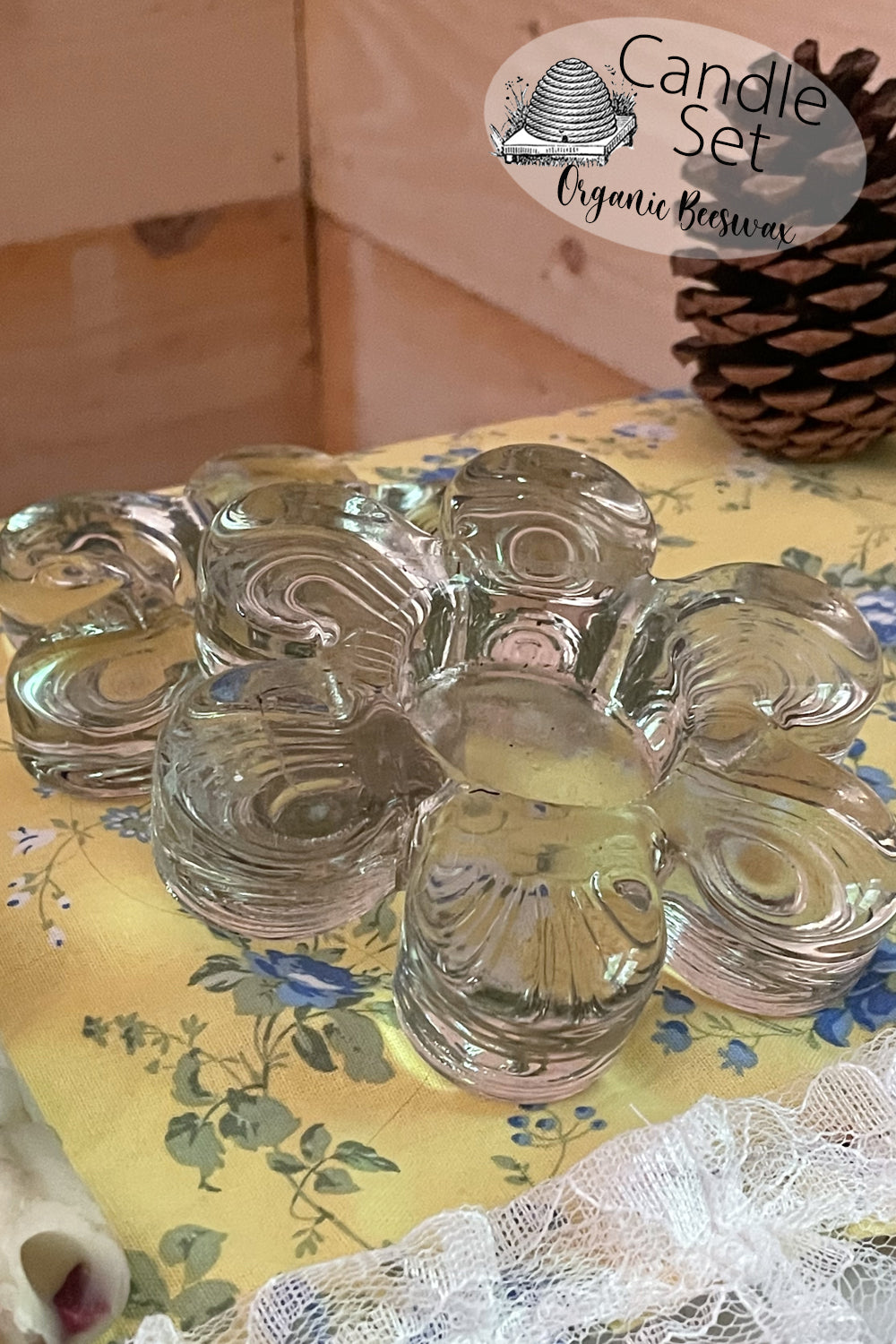 Set of two vintage flower-shaped pressed glass tealight holders shown on a lace-covered table in natural light. Photographed from above and side angles to highlight floral shape and sturdy base.