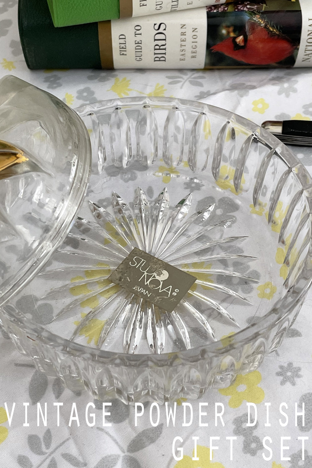 Vintage poinsettia pressed glass powder dish on white crochet linen with warm candlelight and cozy winter styling.