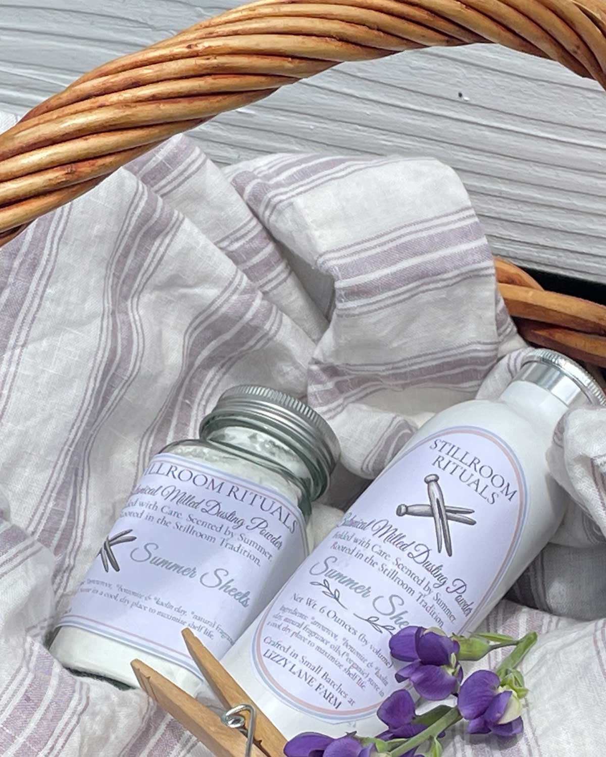 Dusting powder bottles in basket with linen cloth and small purple flowers
