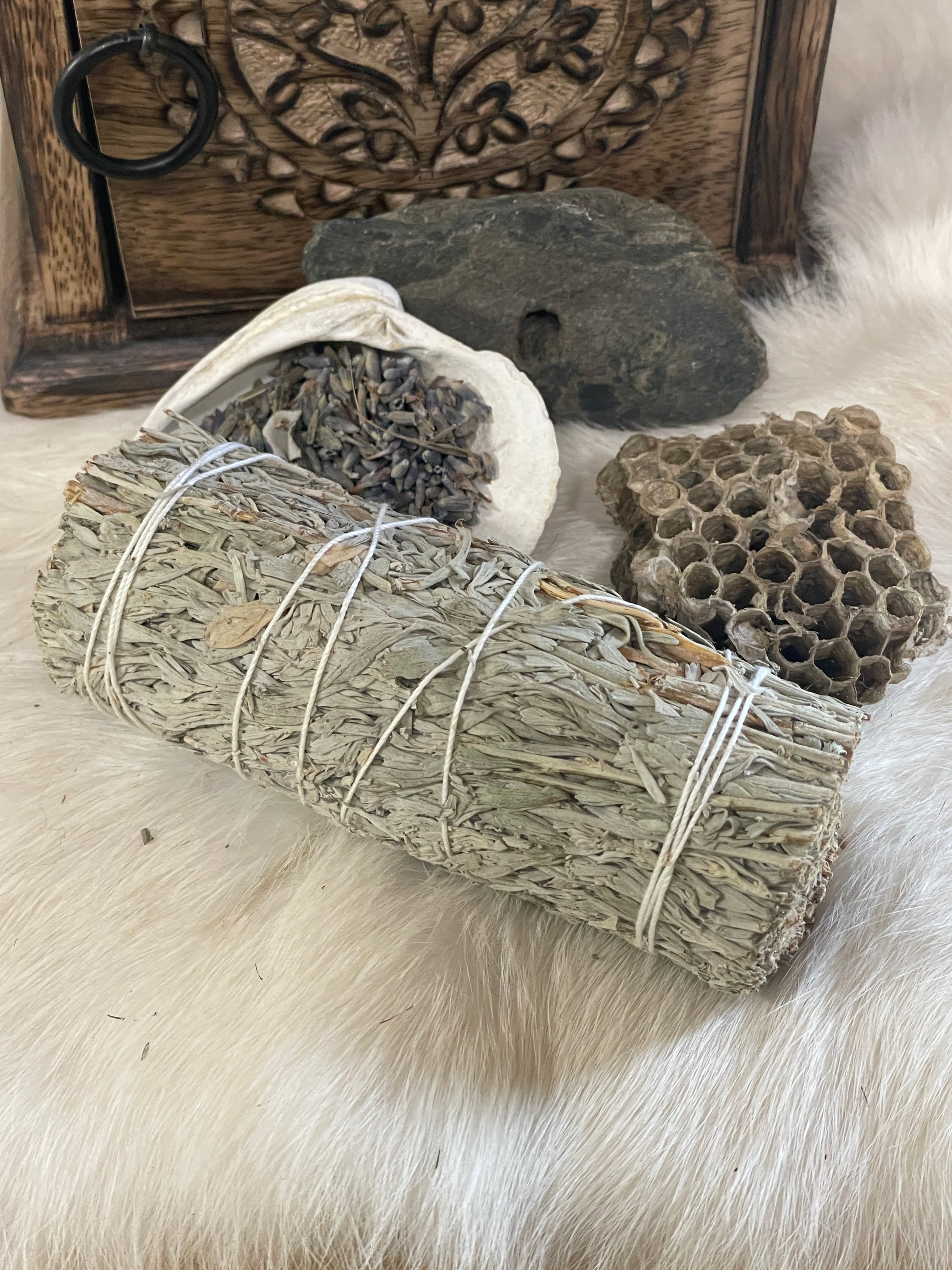 White Copal Smudge Stick- Mountain Sage and Copal Resin resting on white rabbit fur with natural finds close by