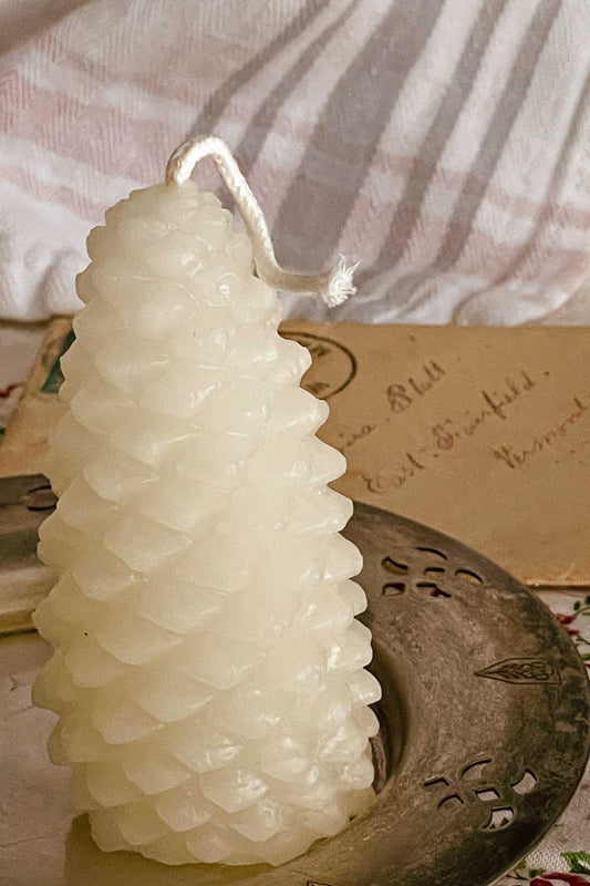 White beeswax pinecone candle displayed on an antique silver dish — a limited Midwinter Archive winter keepsake, perfect for cottagecore gifting.