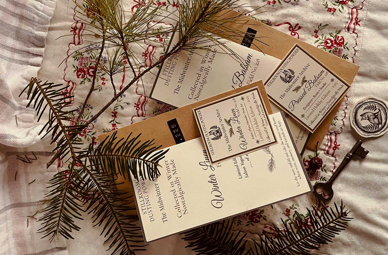 Stillroom archive cards with winter greenery and vintage keys — handmade seasonal packaging for winter dusting powders and holiday gifts.