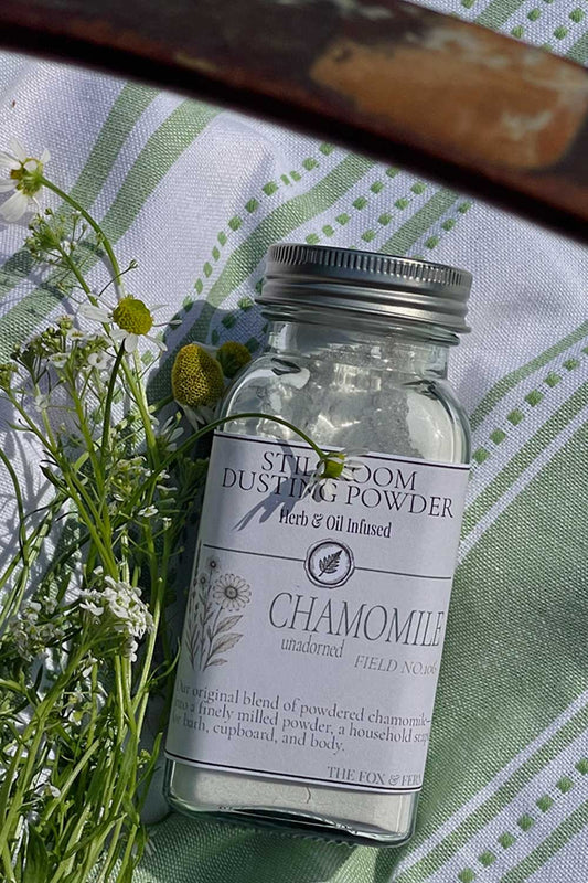 apothecary shaker bottle of chamomile dusting powder in summer basket