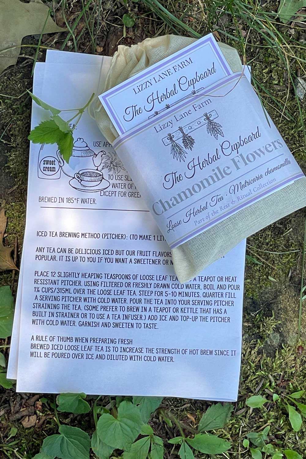 newly packaged chamomile flowers in muslin bag showing the packaging label and included tea brewing guide.