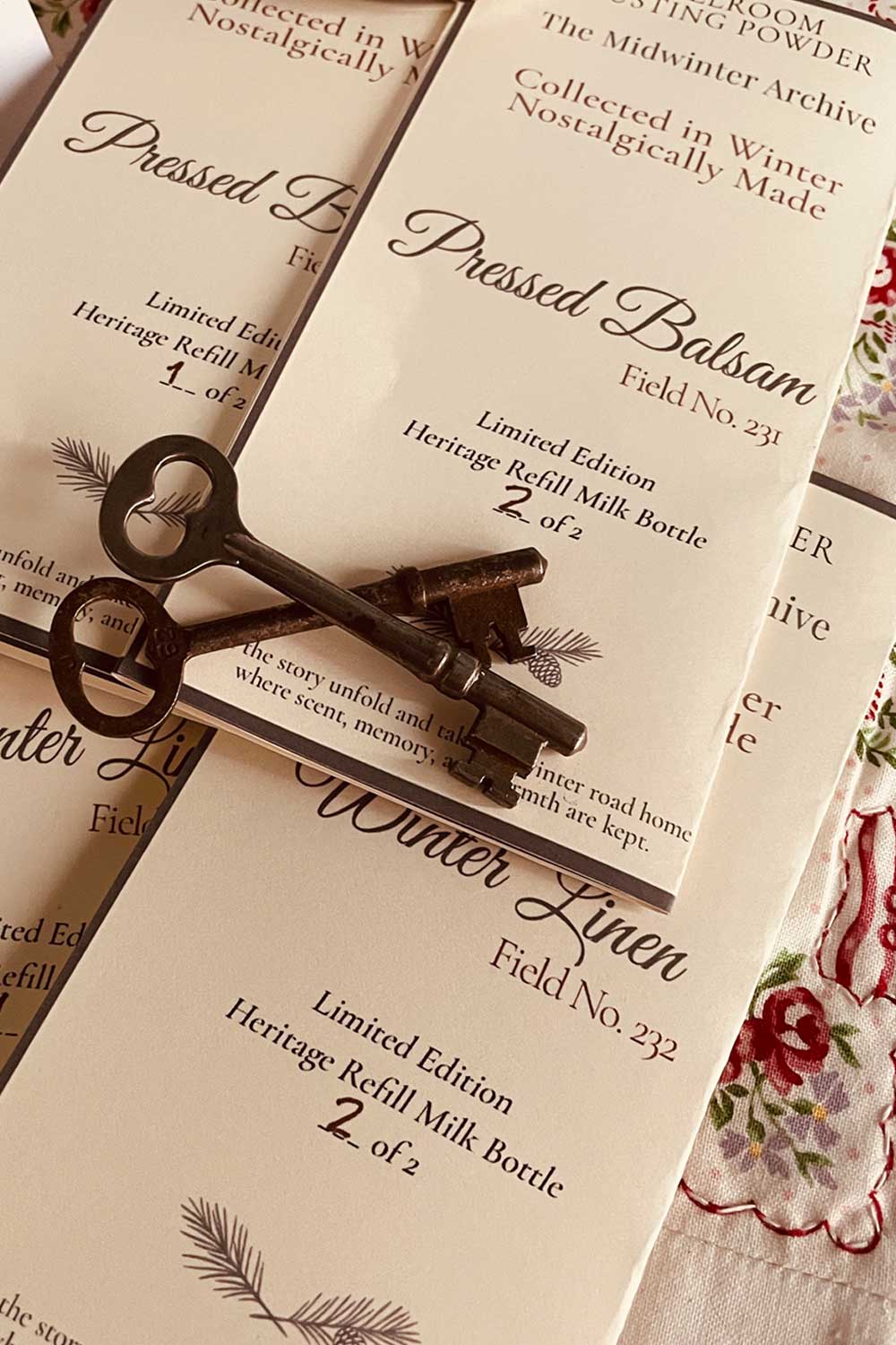 Pressed Balsam and Winter Linen field note cards with vintage keys — limited edition winter dusting powder refill bottles from the Midwinter Archive holiday gift collection.