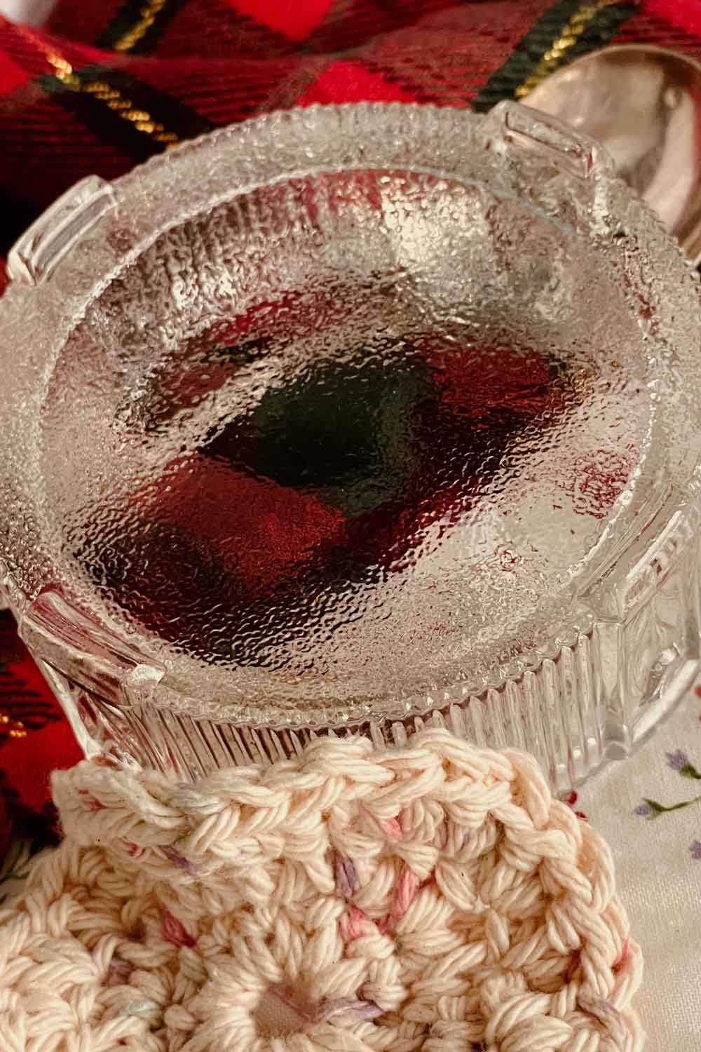 Textured vintage glass powder dish with ribbed sides and handmade crochet puff, warm sepia stillroom photography