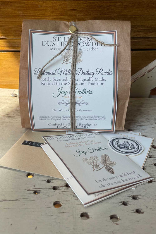 bulk 12 oz package of botanical dusting powder. part of the seasonal woods and weather collection. along with the field not card collection sitting on a rustic table
