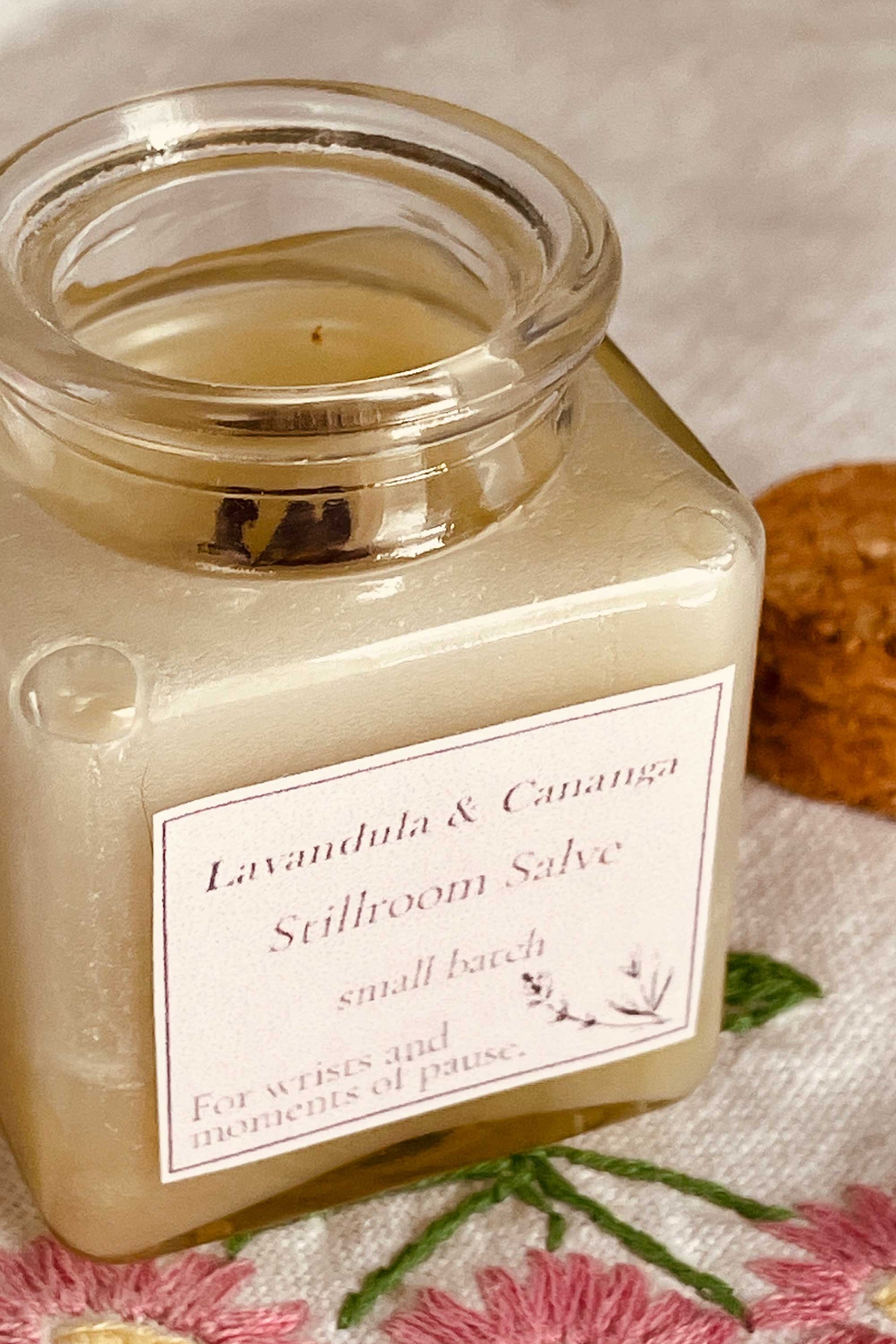 Jar of Lavandula & Cananga Stillroom Salve with a label on a textured surface.