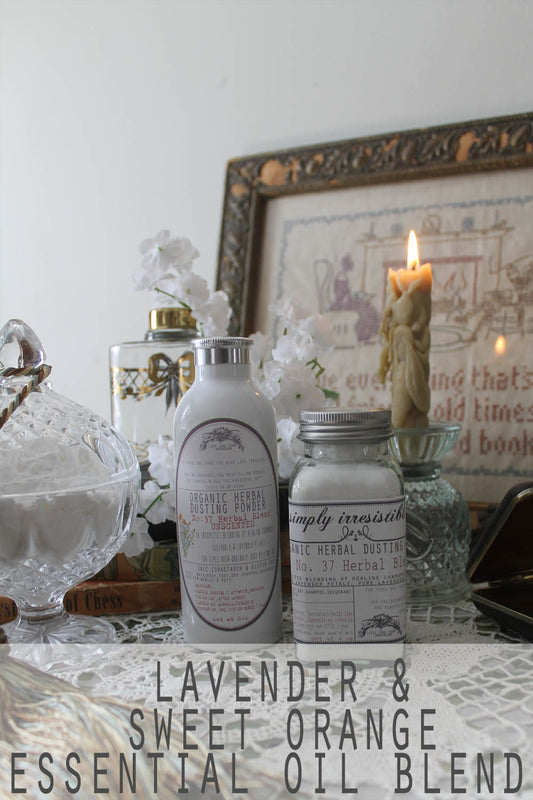 Bottles of lavender and sweet orange infused dusting powder on a vintage dresser. This natural body powder absorbs moisture, soothes skin, and keeps you feeling fresh all day—free from talc, cornstarch, and synthetic fillers. Perfect for a calming and refreshing experience with pure botanical ingredients.