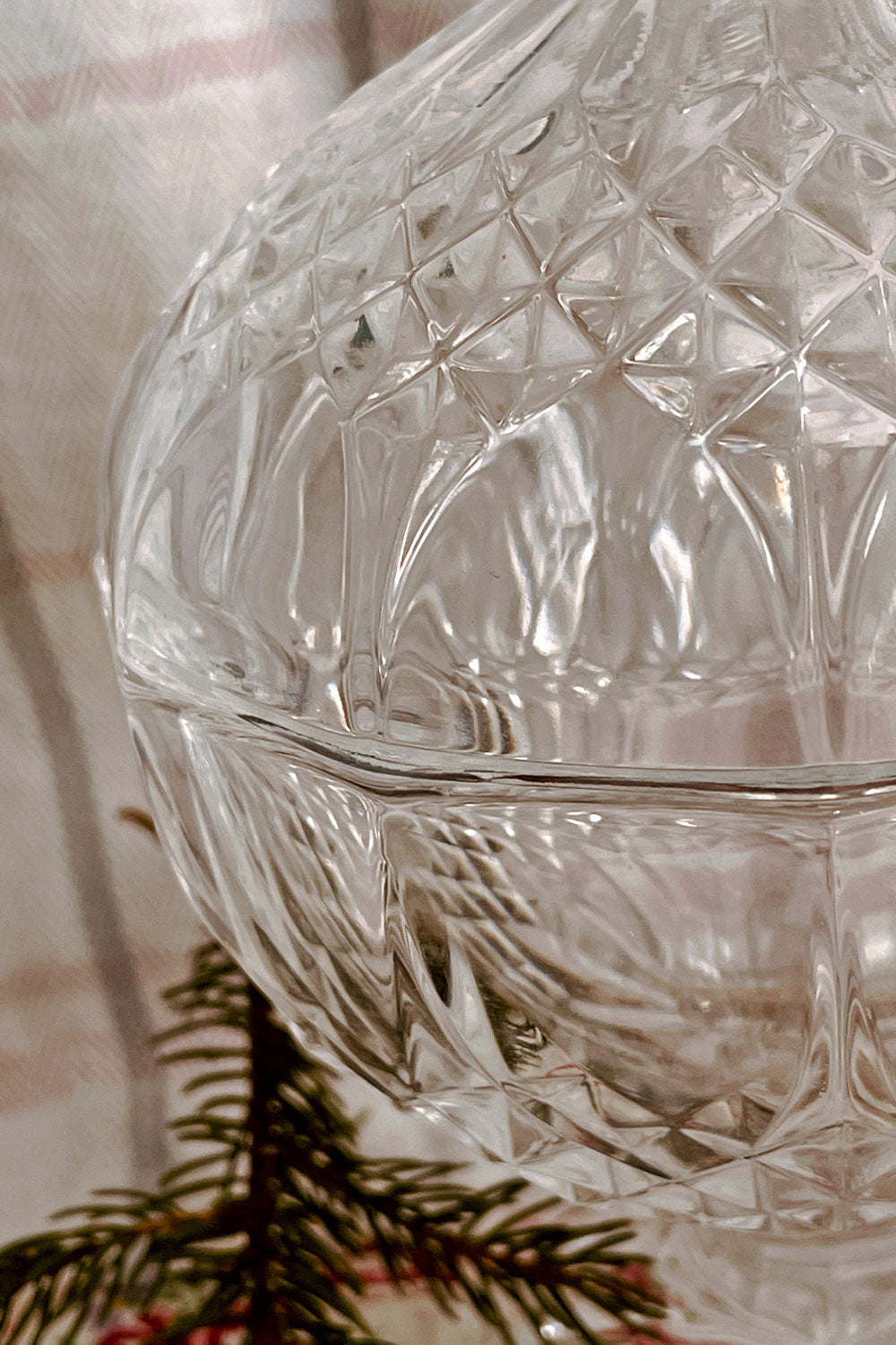 Close detail of crystal powder dish beside handmade puff and vintage silver spoon.