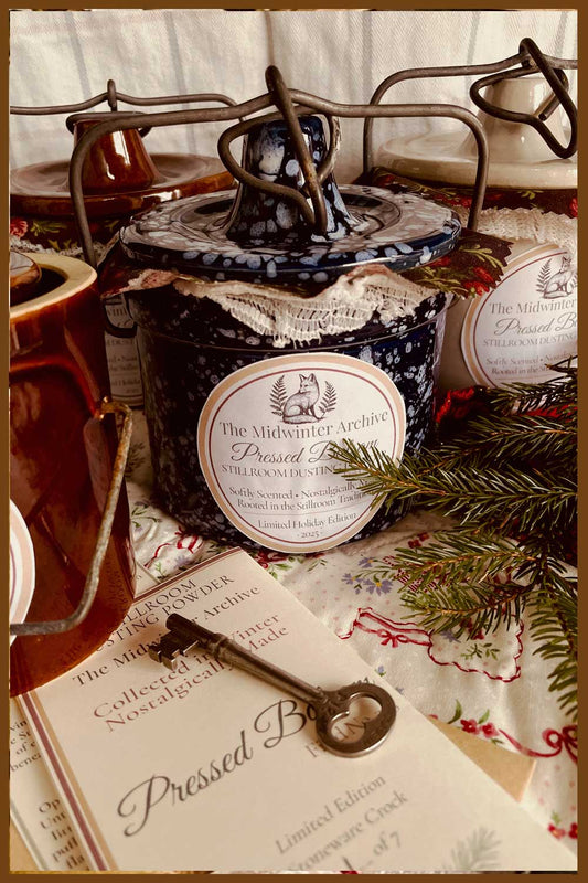 A collection of Midwinter Powder Crocks filled with Pressed Balsam dusting powder, trimmed in lace and calico — a Stillroom Christmas tradition.