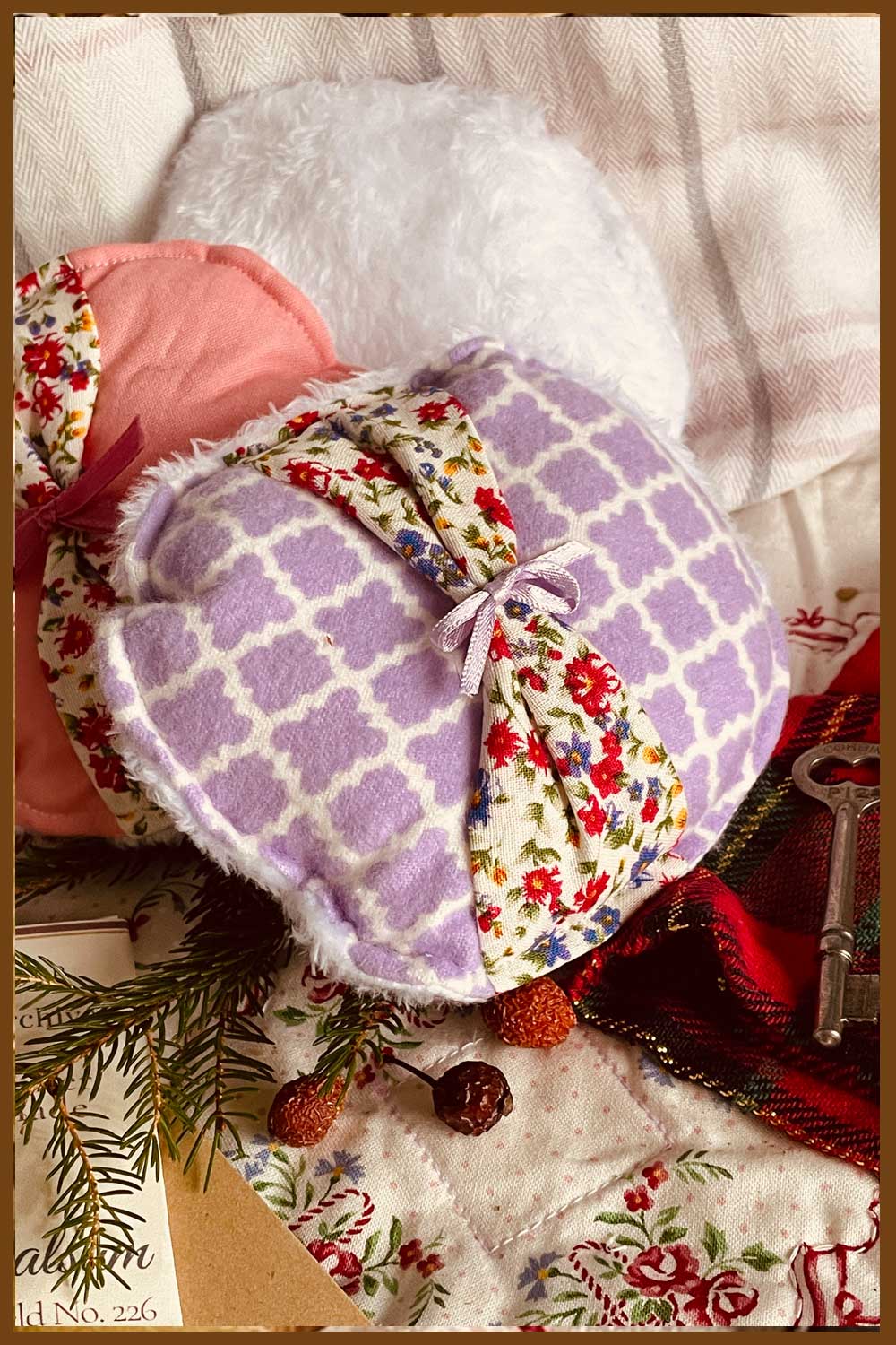 Hand-sewn fabric powder puffs in rose and peach tones — included with the Midwinter Powder Crock, gift-ready for the holiday season.