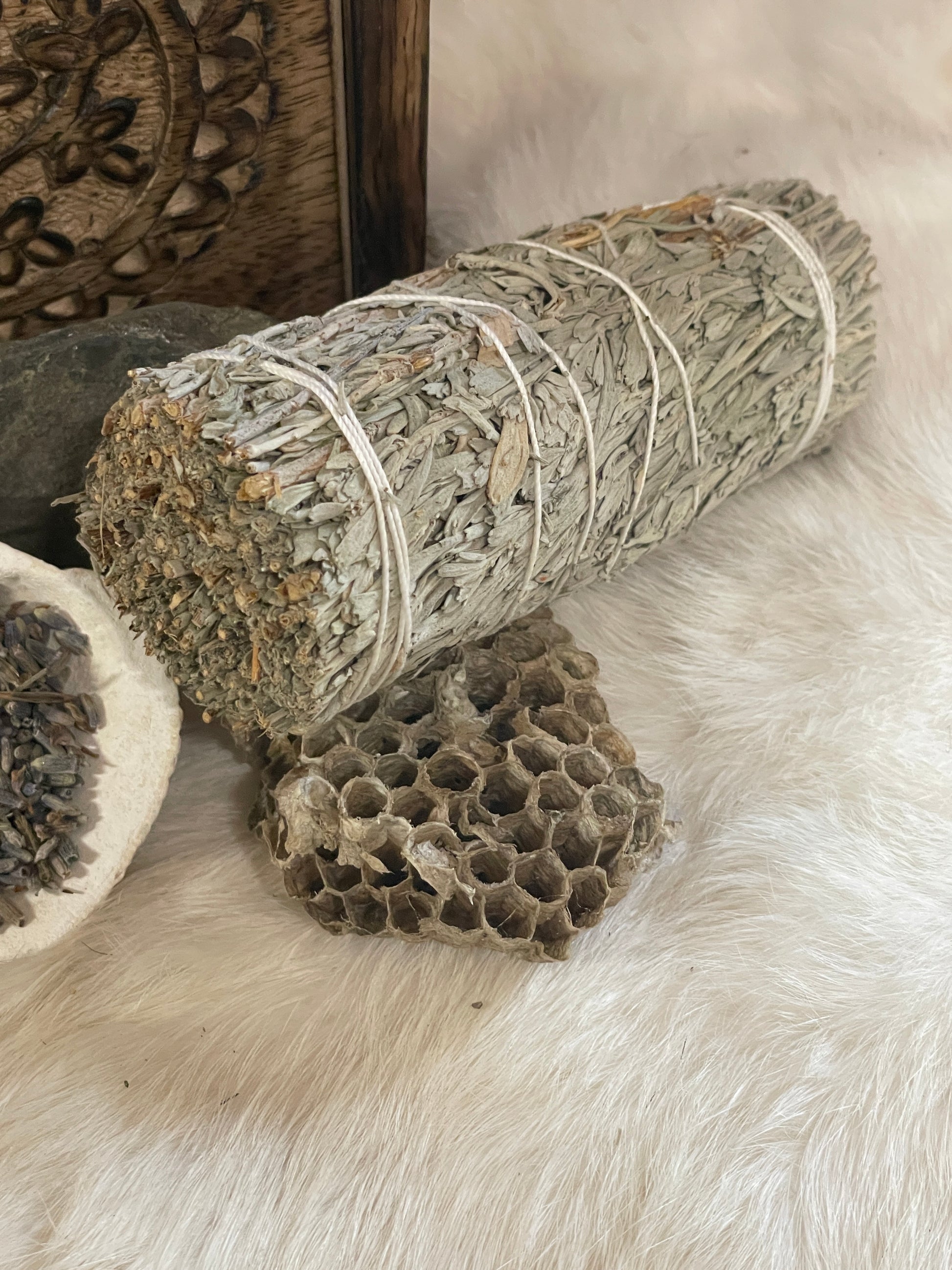 White Copal Smudge Stick- Mountain Sage and Copal Resin close up to show details of the herb bundle gently rested on a found paperwasp nest.