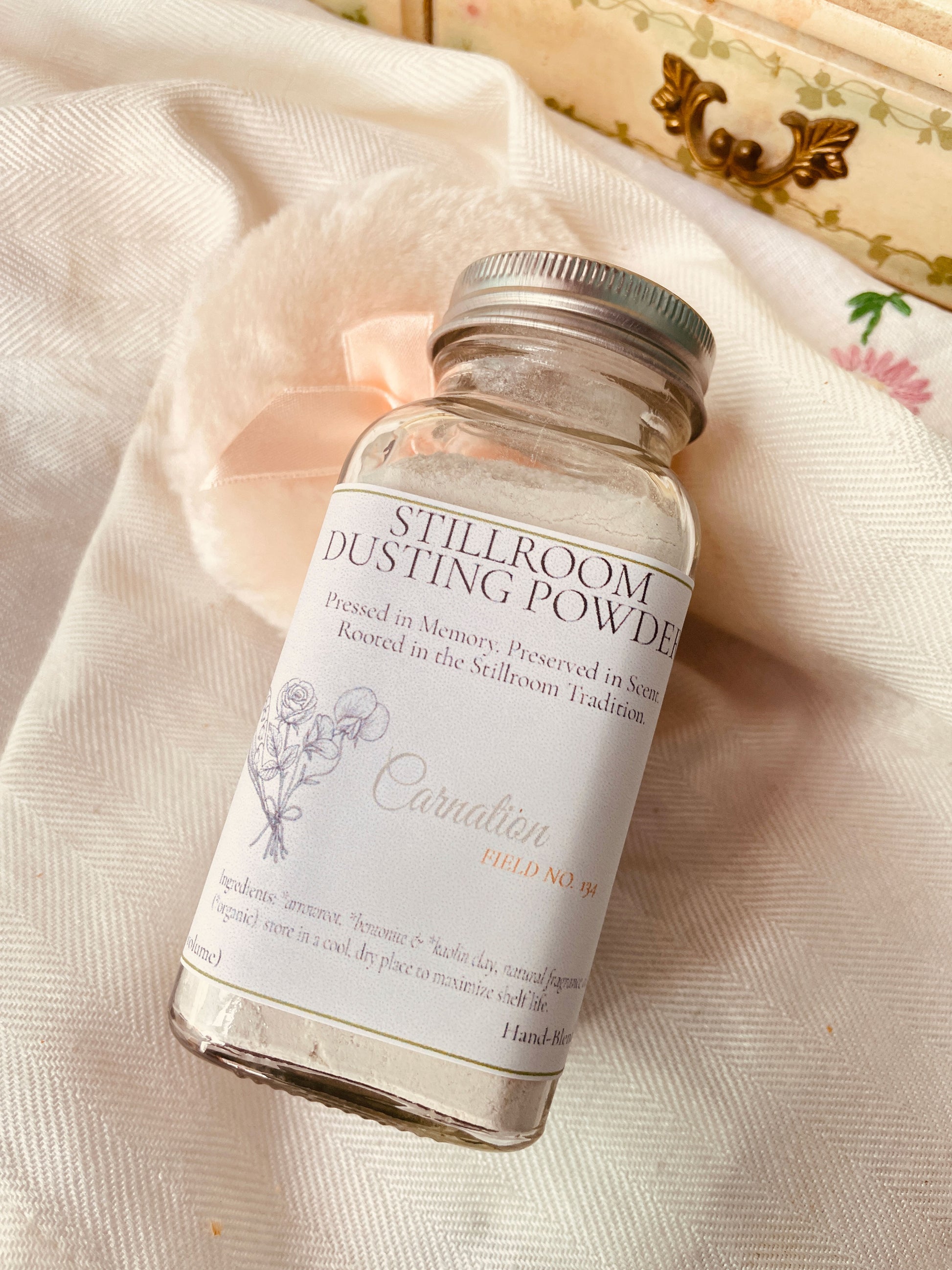 a stillroom essential carnation dusting powder in a traditional apothecary glass shaker bottle