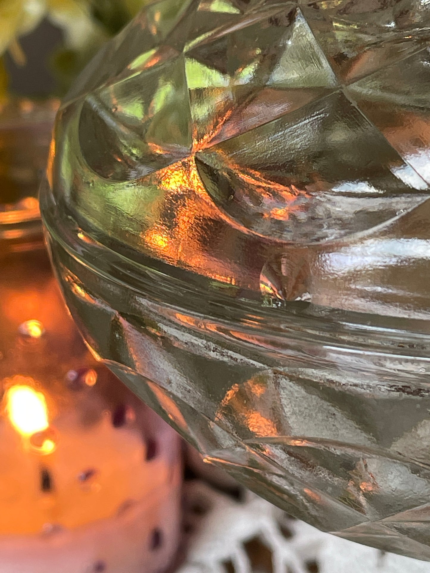 Close-up of vintage vanity dish lid and rim – showcasing glass craftsmanship and soft candlelit ambiance.