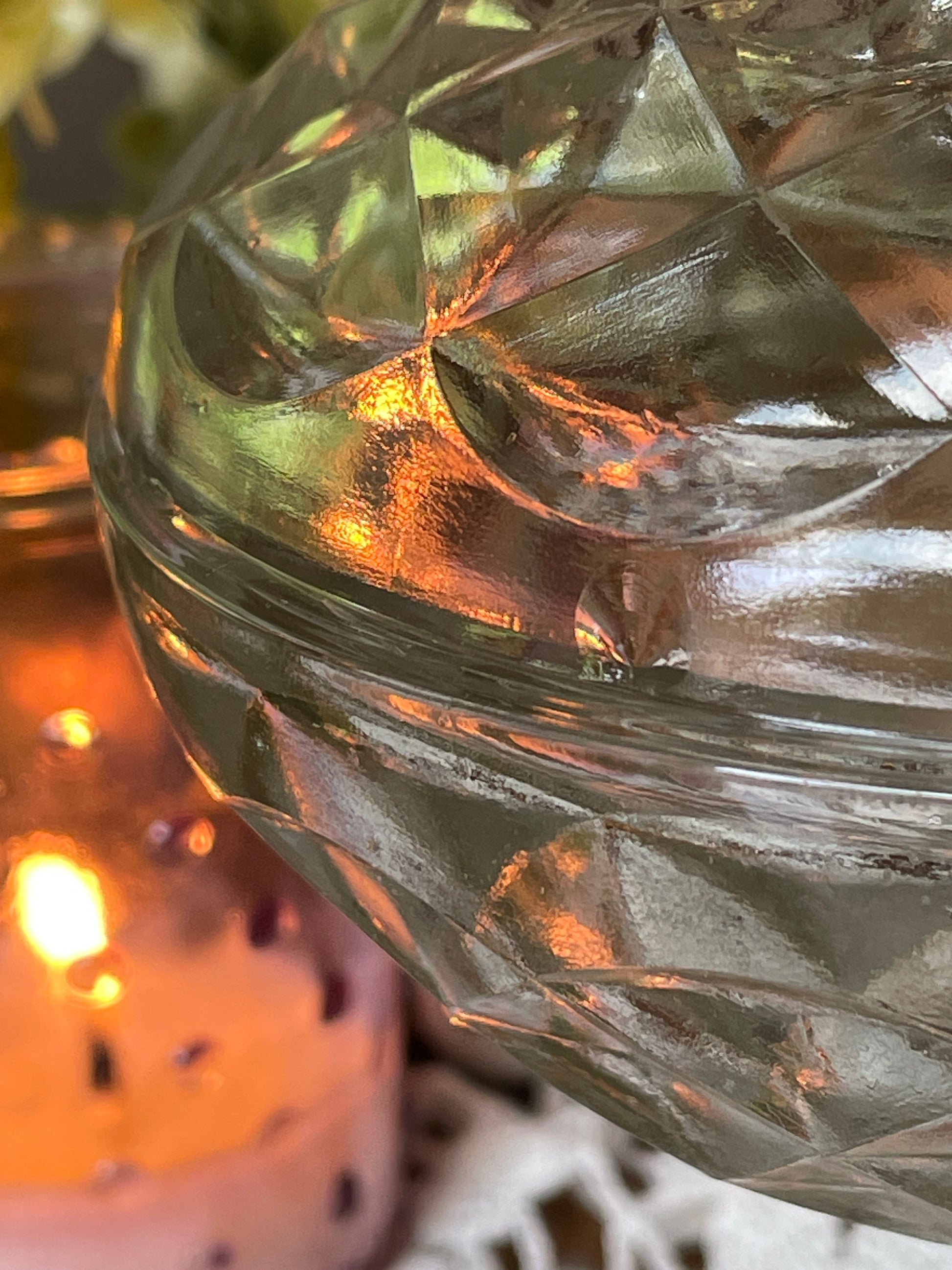 Close-up of vintage vanity dish lid and rim – showcasing glass craftsmanship and soft candlelit ambiance.
