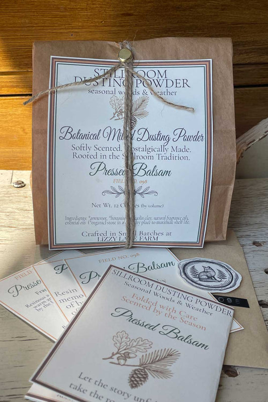 pressed balsam dusting powder part of our seasonal woods & weather collection. large 12 oz bulk package and archival cards sitting on table