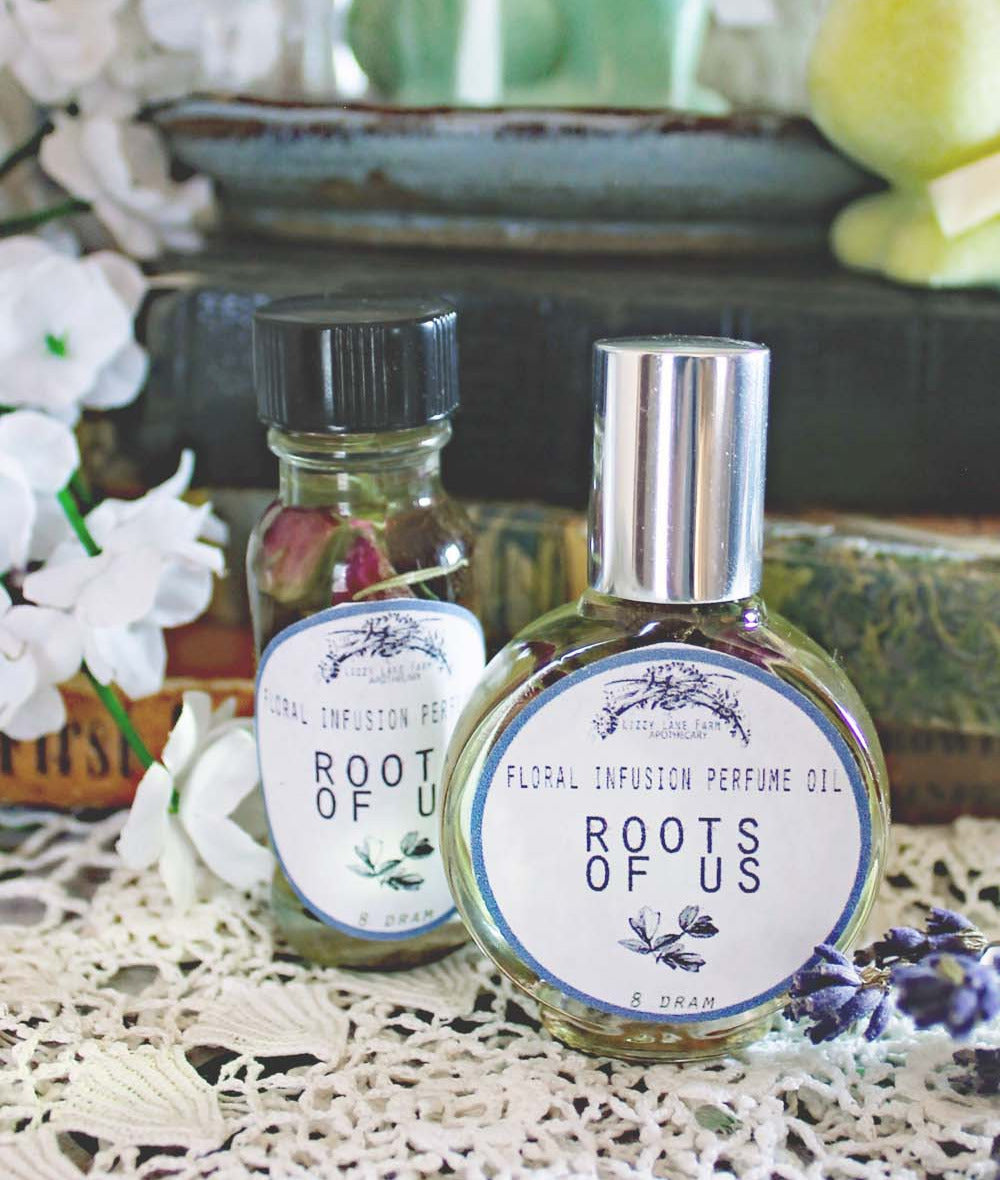 Roots of Us perfume oil – a handcrafted blend of pure 1970s patchouli and lavender, infused with pink rosebuds, allspice, dill seed, uva ursi, and rosemary. Earthy, spicy, and nostalgic fragrance inspired by vintage love, bohemian spirit, and timeless adventure.