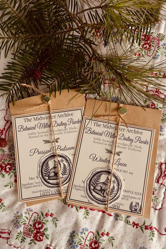 midwinter archive sample powders, pressed balsam and winter linen tucked in on holiday table with winter spruce and pine