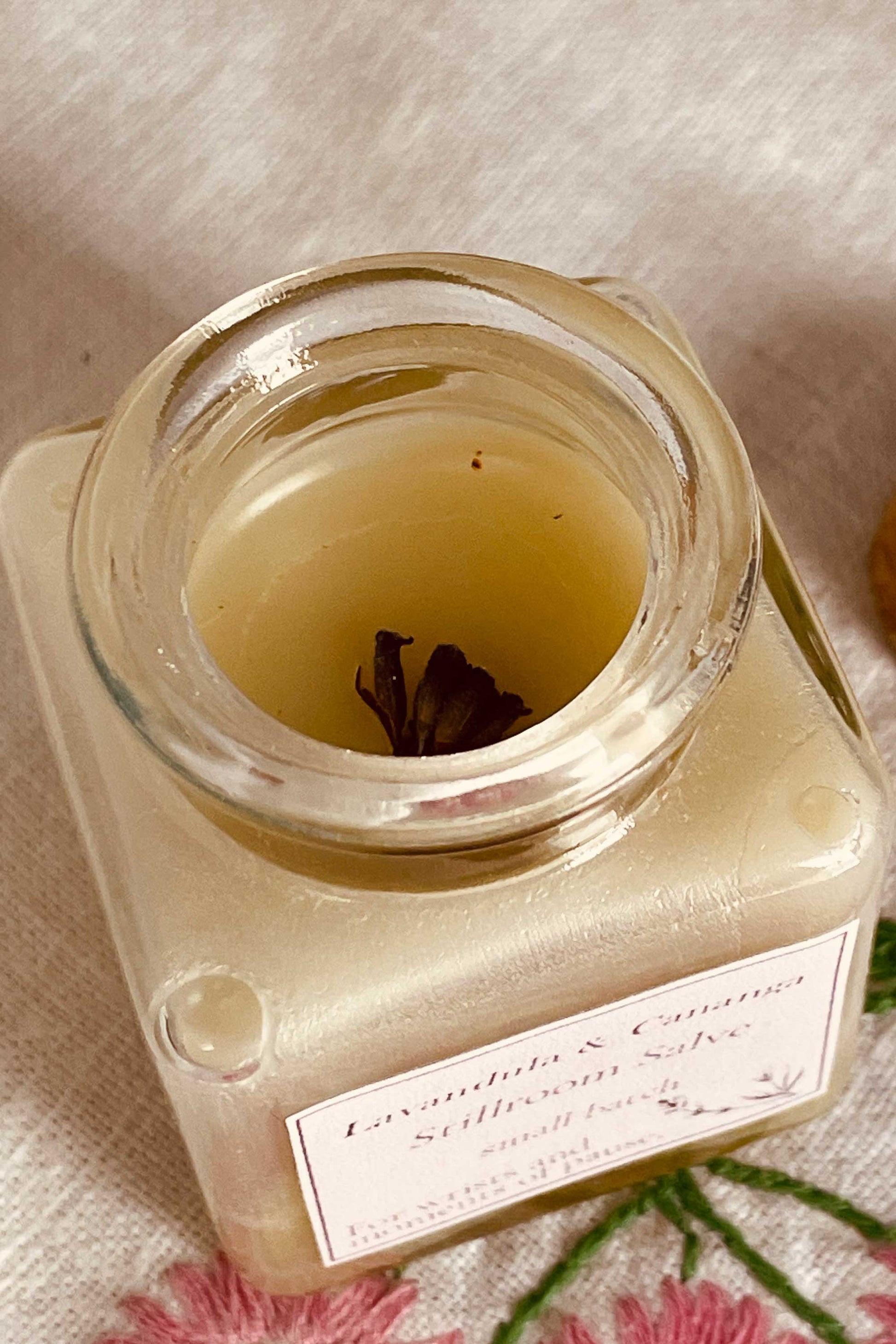stillroom salve open jar with dried lavender buds.