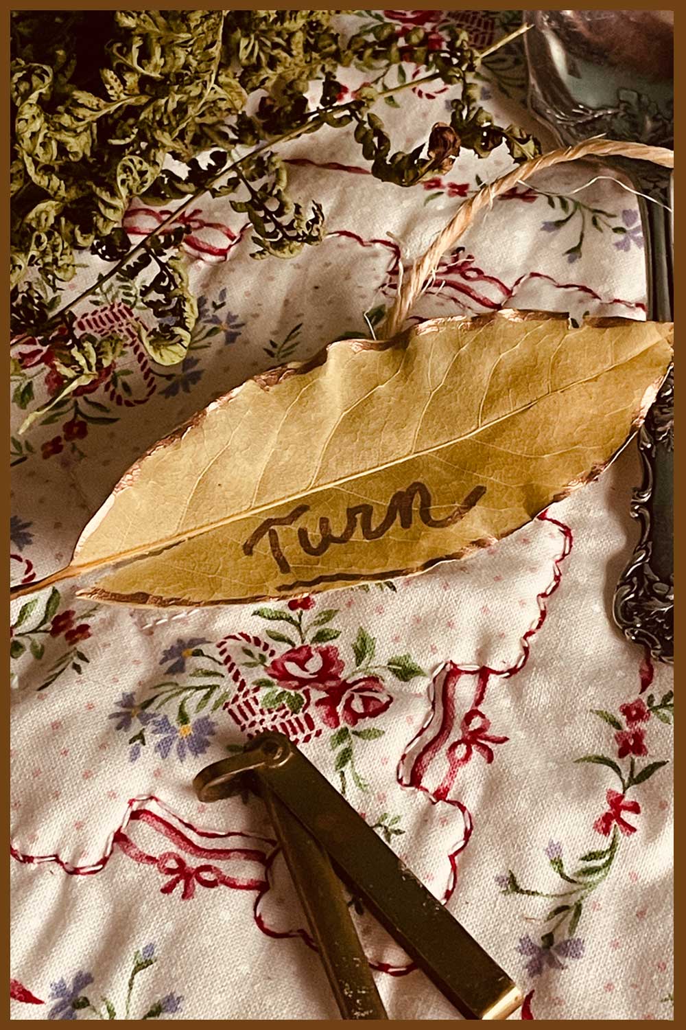A single gold-edged bay leaf marked “turn” — symbolic of reflection and the turning of the season in the Stillroom Christmas collection.