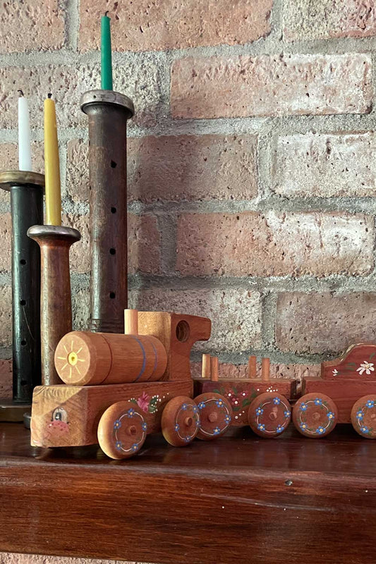 Vintage Folk art painted Wooden toy train set against a brick wall