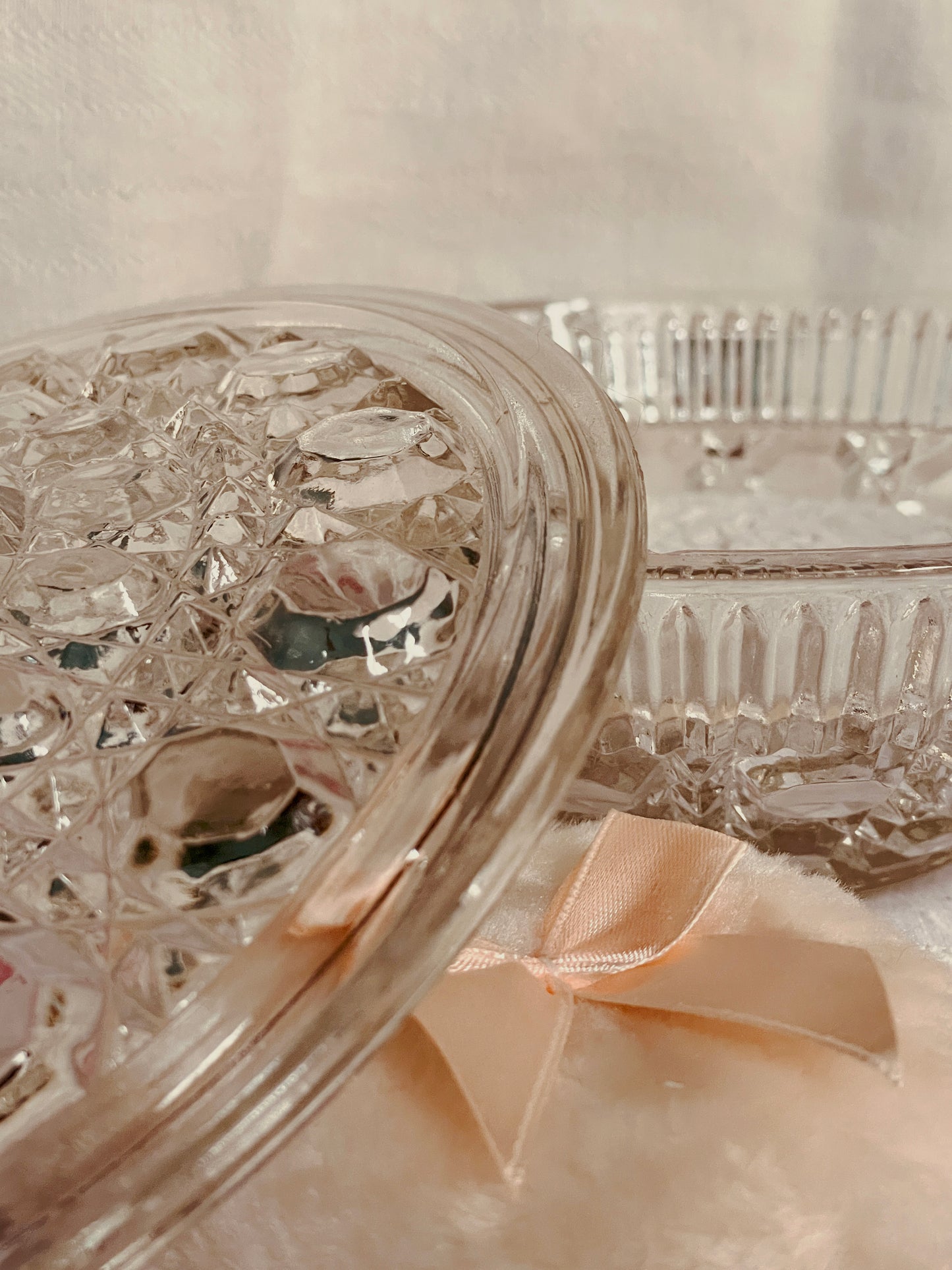 Close detail of vintage Button & Cane pressed glass lid showing raised geometric pattern and clear glass texture.