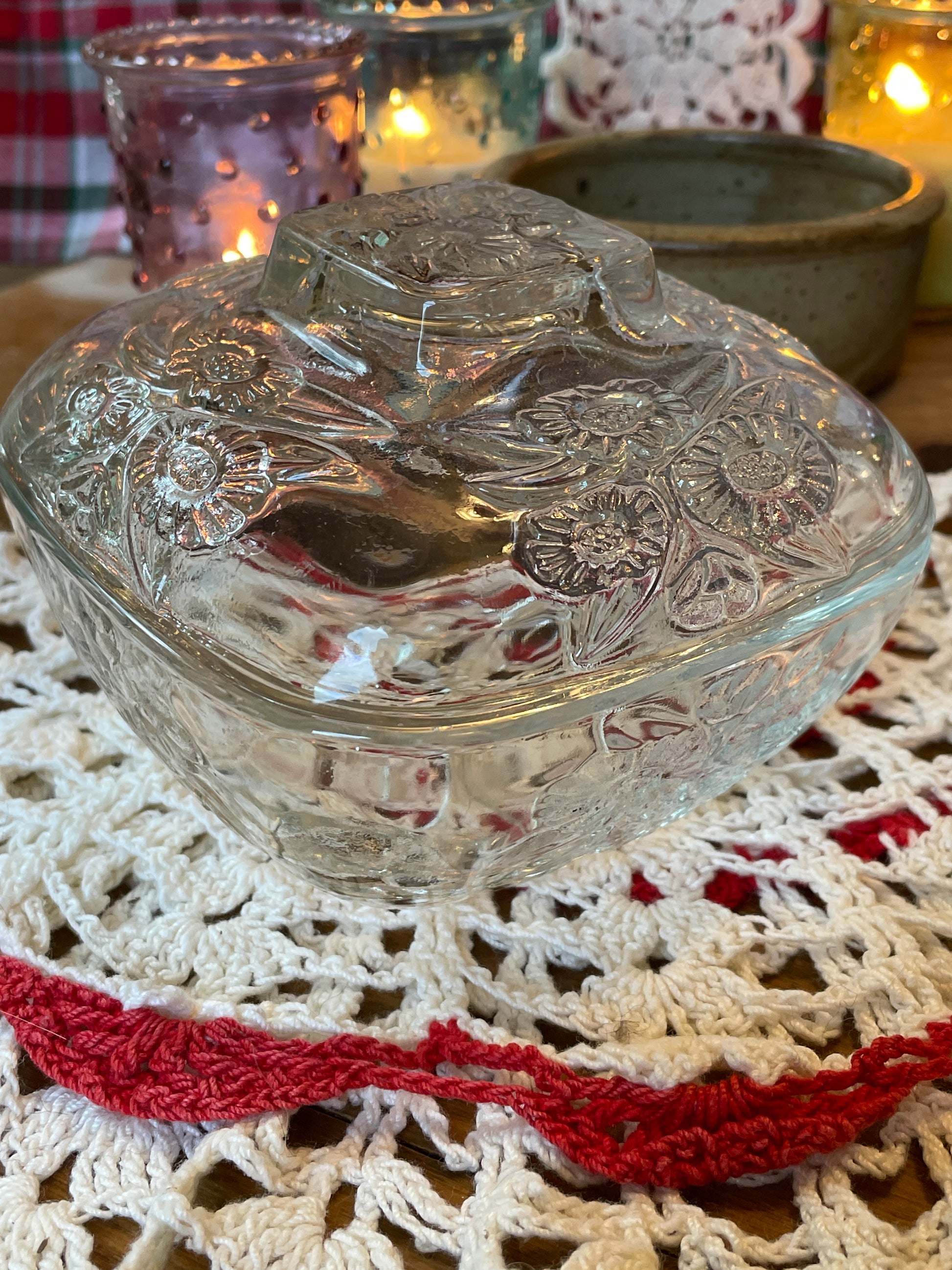 Close-up of lid and dish vintage body powder dish featuring daisy pattern glasswork and warm candlelight in the background – New England antique vanity decor.