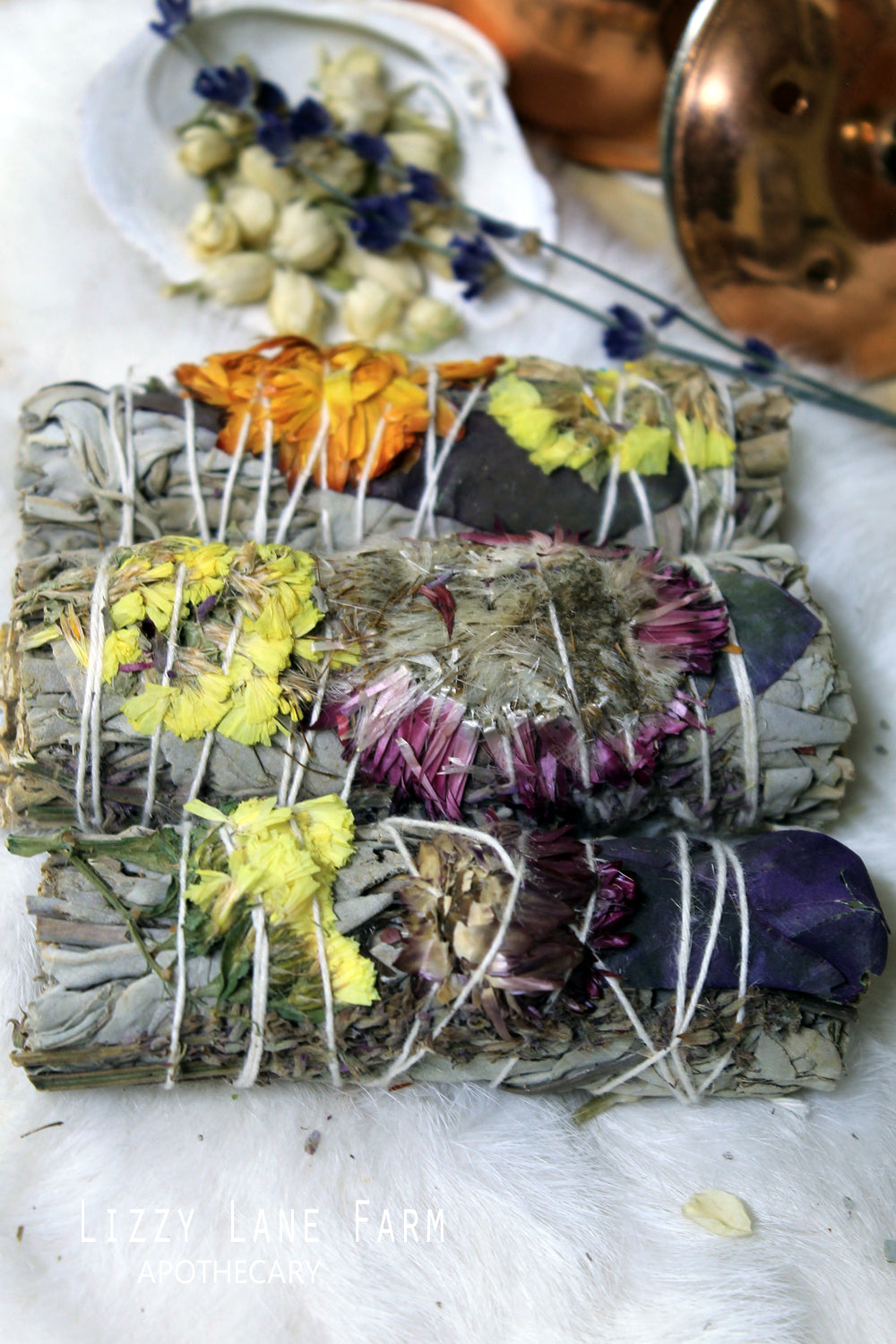 Bright resin, soft sage, and a little burst of color. detail close up of the herb bundle showing the delicate dried flowers woven into it