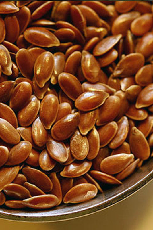 A close-up of freshly dried organic flax seeds in a rustic wooden bowl—rich brown, glossy, and ready for the kitchen.