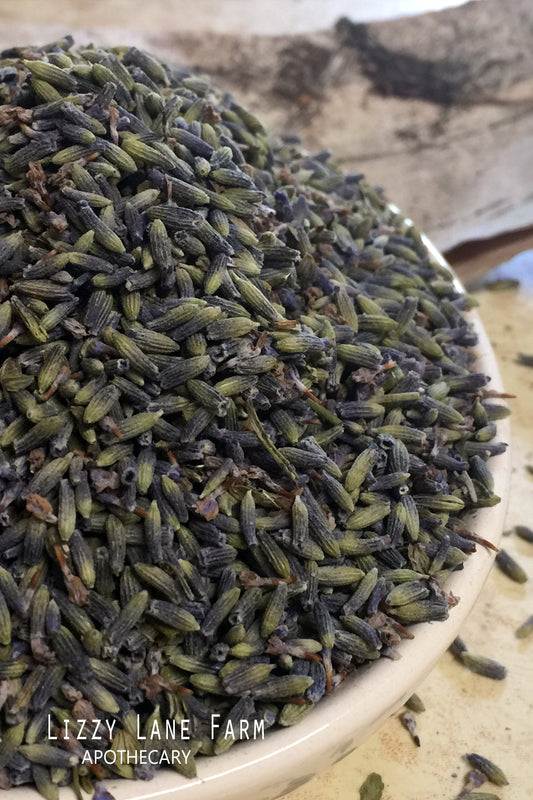 Vintage Blue Mason Jar with Organic Craft Lavender Buds – A close-up of dried organic lavender buds spilling from an overflowing mixing bowl, showcasing their smoky purple hue and fragrant quality.