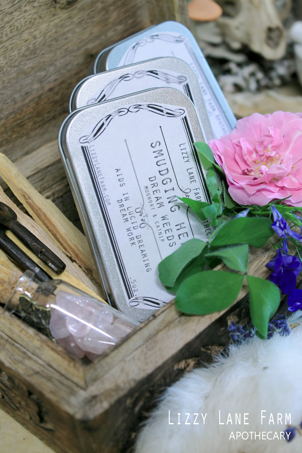a close up of the herbal tin collection- white sage, dream herbs, and palo santo chips. 
