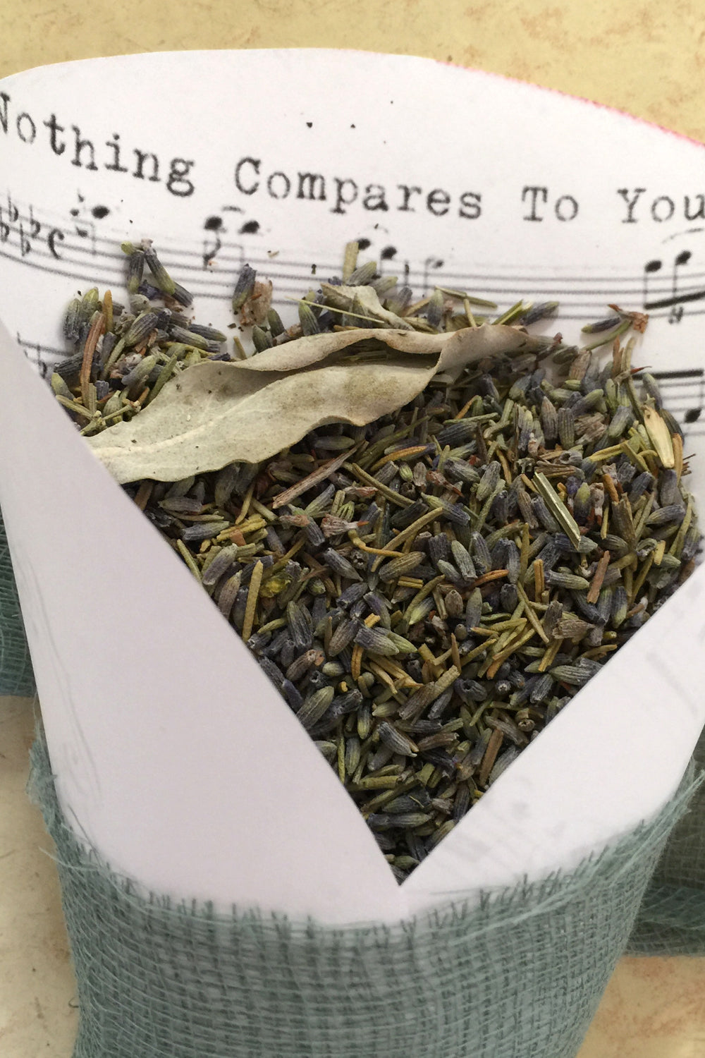 Lavender in a wedding toss cone: A rolled piece of sheet music filled with ultra blue lavender buds, showcasing the luxurious lavender color, ideal for premium eco friendly wedding toss.