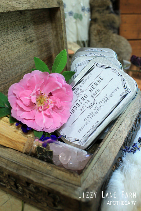 White Sage Smudging Herb Tin, close up of details of tin tucked in a wooden box with natural flowers tucked in